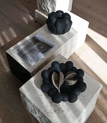 Cuencos de cerámica negra sobre mesas de piedra minimalistas